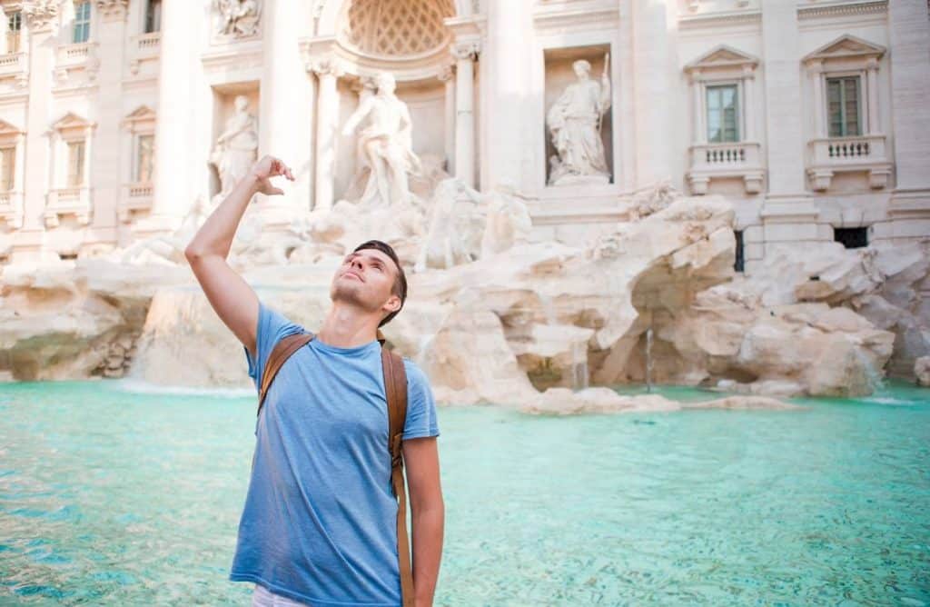 touriste qui jette une pièce dans la fontaine de trévi